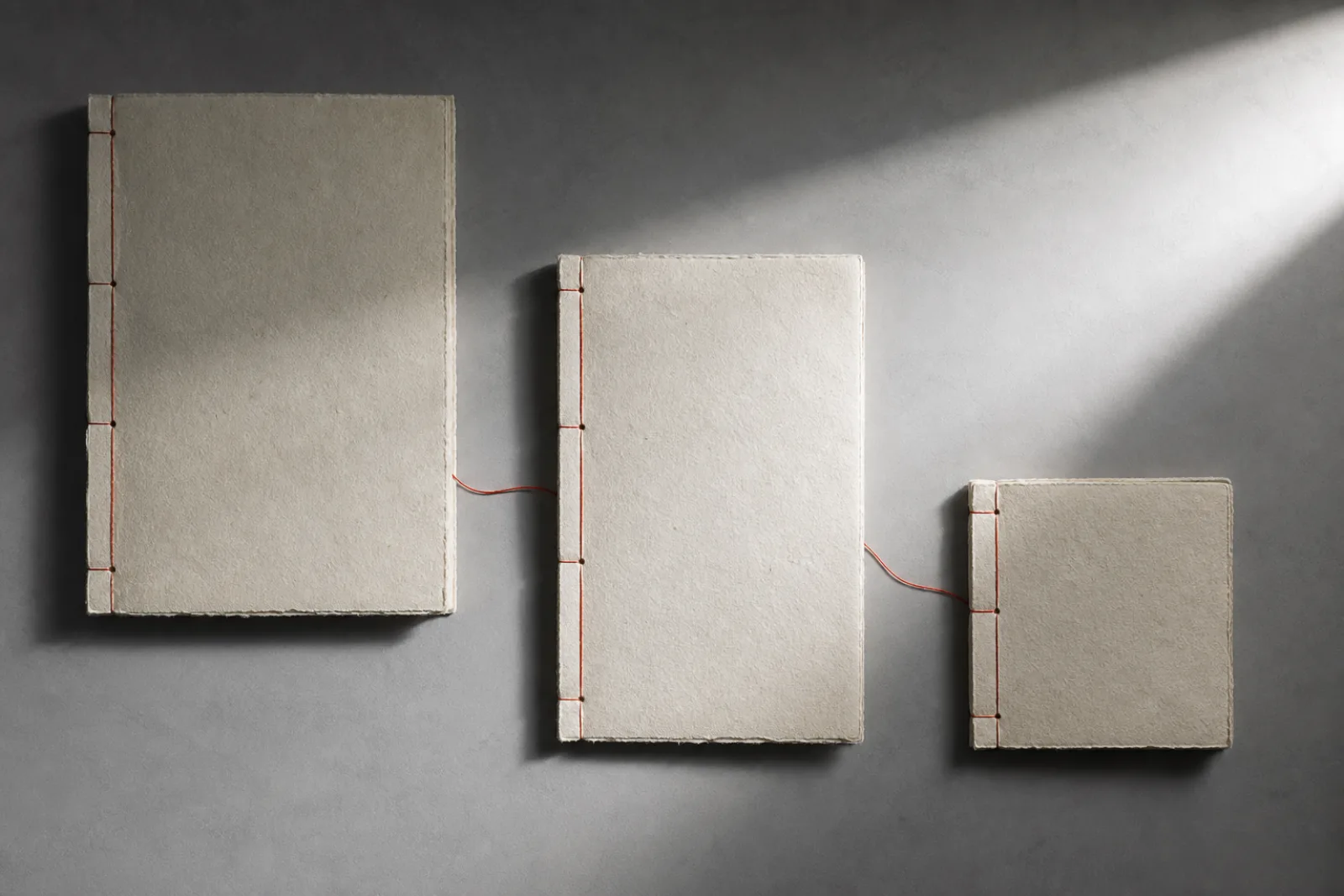 Three paper folios connected by a red thread